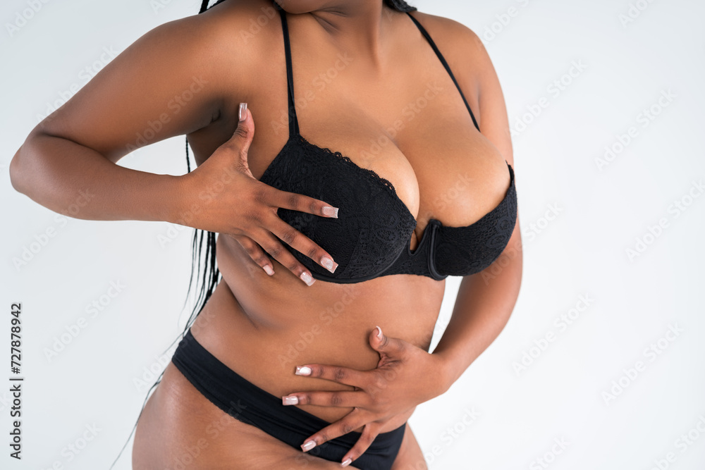 Curvy busty plus size model with big breasts in push up bra on gray background, overweight African black woman in sexy lingerie, large boobs, body positive concept Curvy busty plus size model with big breasts in push up bra on gray background, overweight African black woman in sexy lingerie, large boobs, body positive concept