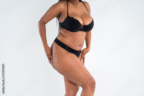 Curvy busty plus size model in push up bra on gray background, overweight African black woman in sexy lingerie, fat body with cellulite