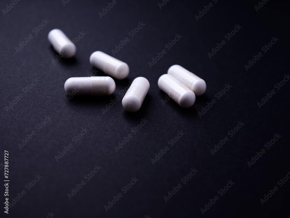 Creatine capsules on dark paper background. Soft focus. Close up. Copy space.
Creatine capsules on dark paper background. Soft focus. Close up. Copy space.