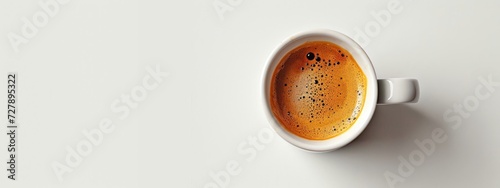 A close-up shot featuring a white coffee cup filled with coffee, set against a pristine white background, evoking simplicity and elegance.