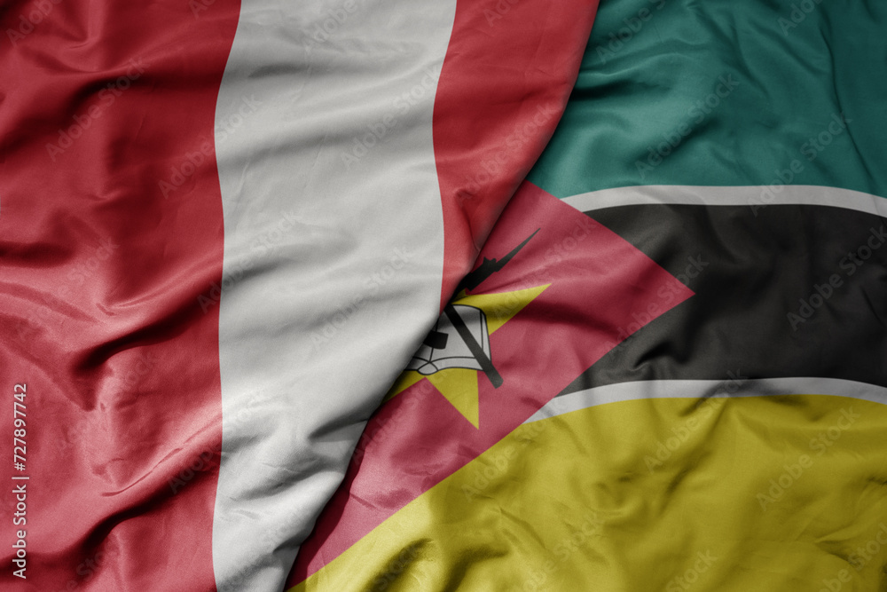 Fototapeta premium big waving national colorful flag of mozambique and national flag of peru .