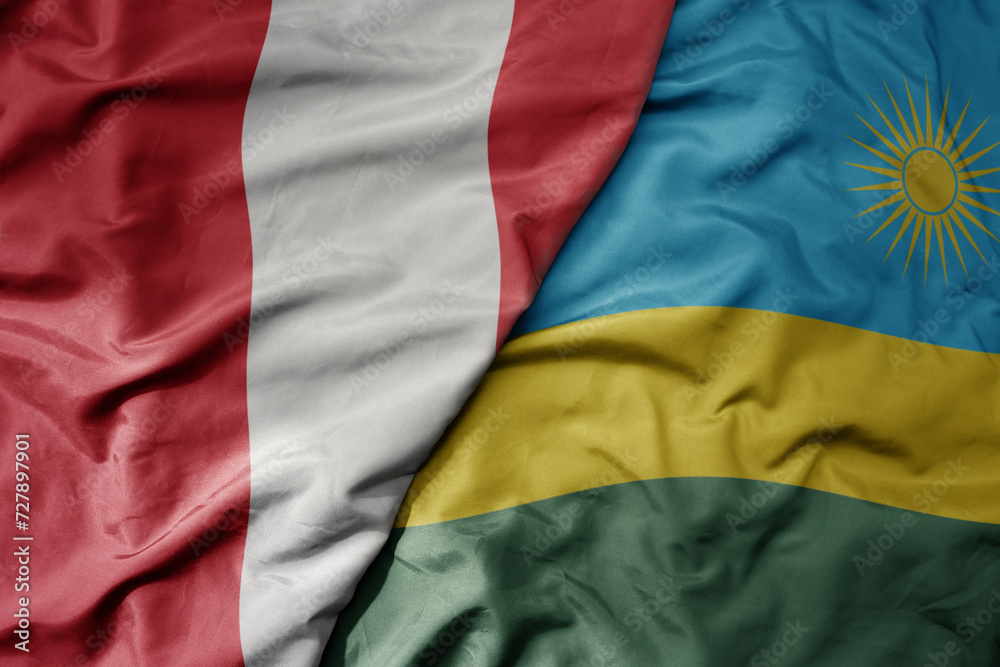 big waving national colorful flag of rwanda and national flag of peru .