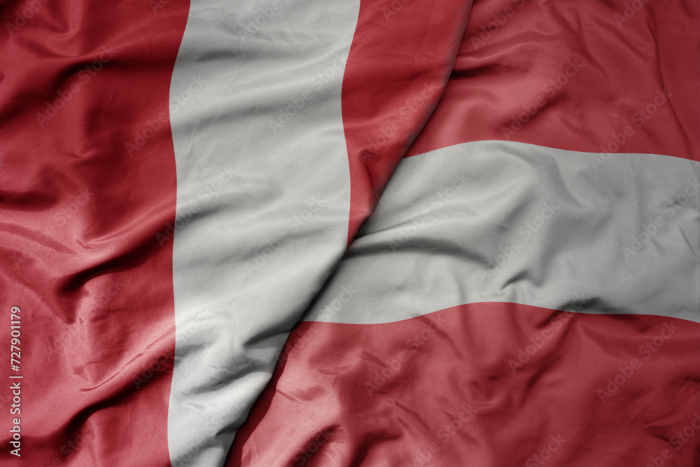 big waving national colorful flag of austria and national flag of peru .