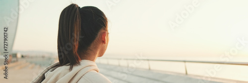 Close up, asian girl in sportswear stands at morning time on the sea background, Back view, Panorama