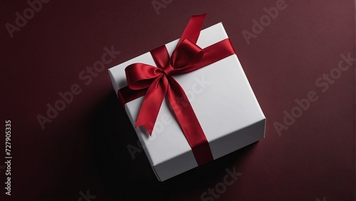 Blank white gift box open or top view of white present box tied with red ribbon bow isolated on dark red background with shadow