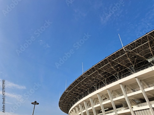 Architectural photo of part of a football stadium with blue sky in the background.