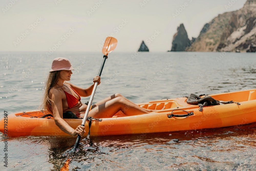 Kayak sea woman. Happy attractive woman with long hair in red swimsuit, swimming on kayak. Summer holiday vacation and travel concept.