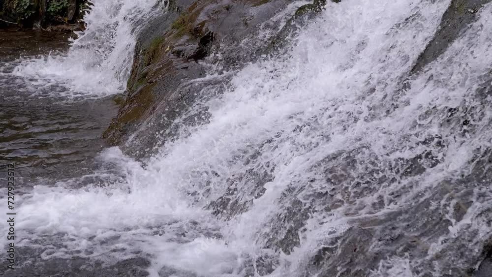 Close-up, View of a Mountain Stream or Waterfall in the Carpathian Mountains. A rapid stream of water flows over rocky cliffs into the river. Picturesque view. Forest. Water background. Slow motion. Close-up, View of a Mountain Stream or Waterfall in the Carpathian Mountains. A rapid stream of water flows over rocky cliffs into the river. Picturesque view. Forest. Water background. Slow motion.