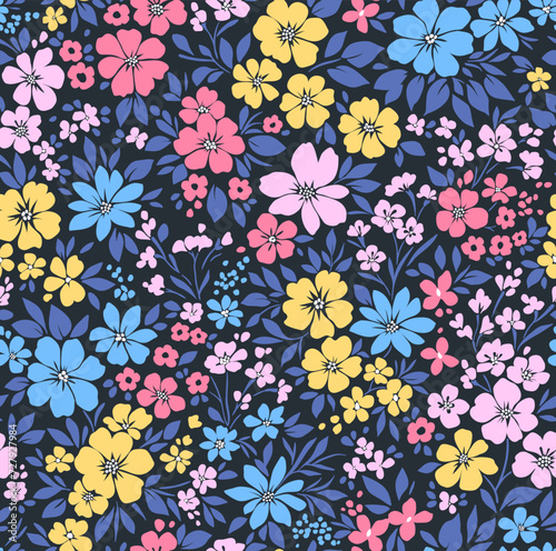 Beautiful floral pattern in small abstract flowers. Small blue  pink and yellow flowers. Blue background. Ditsy print. Floral seamless background. Liberty template for fashion prints. Stock pattern.