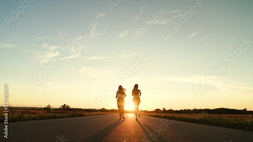 two friends running sunset, team group girls running sunset, silhouette athletic girls, teamwork sport training, athletics fitness, woman runner running sunlight, healthy group, successful player photo