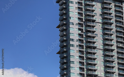 Side of tall building with a blue sky background at daytime.