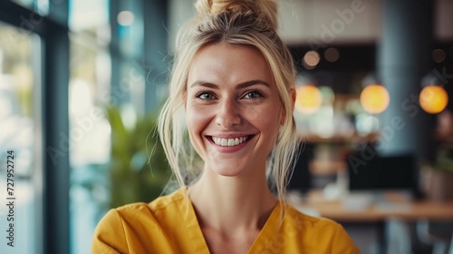 Glowing Portrait of a Cheerful Young Woman with blonde hair and Warm Smile in a agency Indoor Setting with Soft Lighting