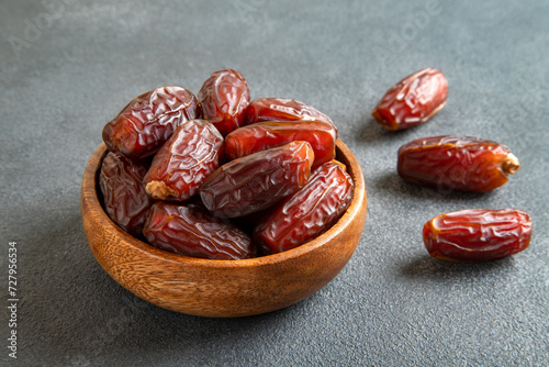 Date fruits in wooden bowl,on black  background.Top view