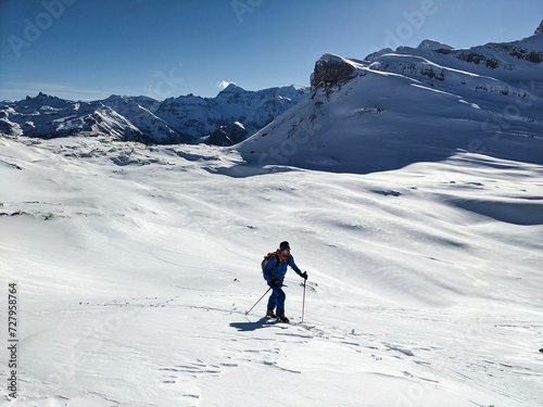 Wallpaper Mural Ski mountaineer runs through a beautifully snowy mountain landscape in Glarus Schwyz. Ski tour on the Pfannenstock. Ski mountaineering in the Swiss Alps. Ski touring in winter. High quality photo Torontodigital.ca