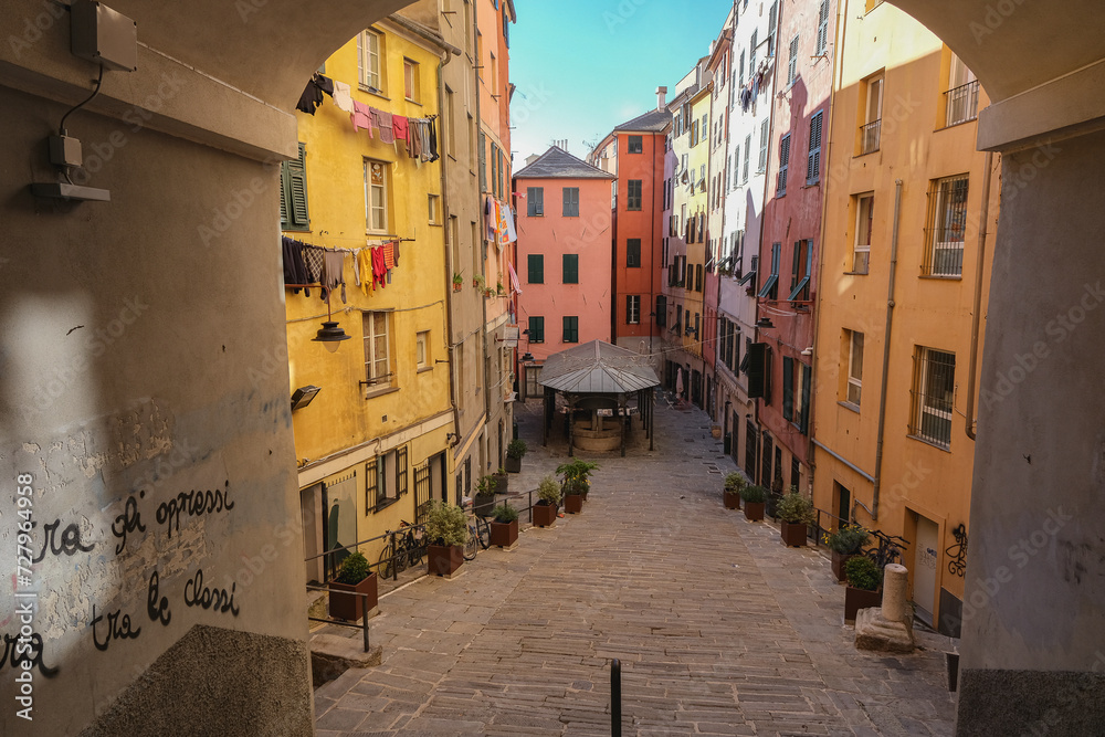 Romantic backstreet, side street or alley in historic old town of Genoa, Italy with historic Mediterranean style architecture facades, a landmark sightseeing tourist spot in downtown