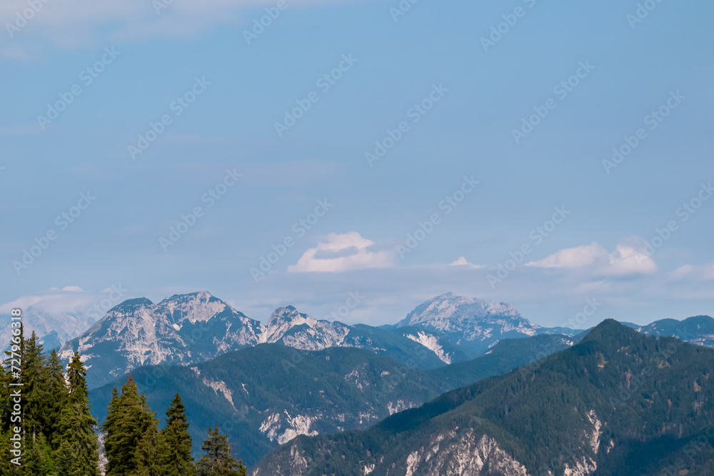 Panoramic view from lift station Monte Lussari in untamed Julian Alps in Camporosso, Friuli Venezia Giulia, Italy. Looking at majestic mountain peaks of Carnic Alps, border to Austria. Monte Scinauz