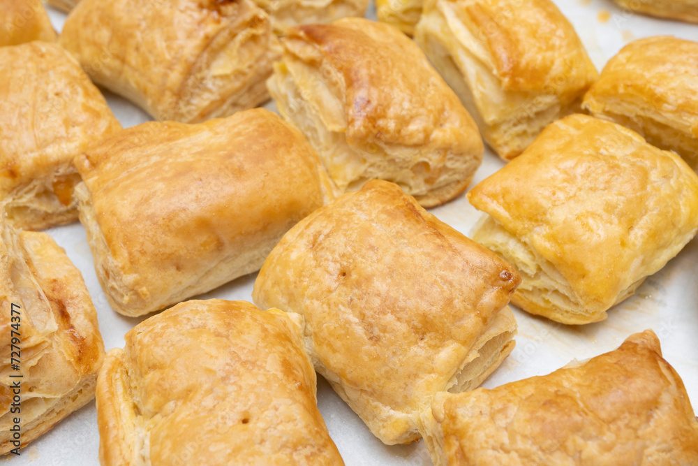 freshly baked puff pastry squares with cheese in tray