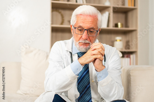 Wallpaper Mural Sad tired mature senior male doctor in medical uniform in hospital or doctor office. Unhappy General Practitioner GP therapist professional healthcare expert in clinic. Healthcare concept Torontodigital.ca