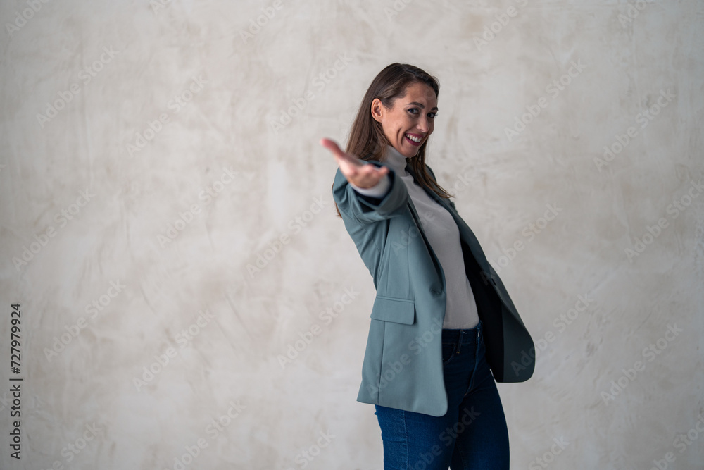 Woman, portrait and pointing to you in studio for choice, vote for winner and decision to volunteer on gray background. Smile, open palm hand and recruitment for hiring and invitation to join us. Woman, portrait and pointing to you in studio for choice, vote for winner and decision to volunteer on gray background. Smile, open palm hand and recruitment for hiring and invitation to join us.