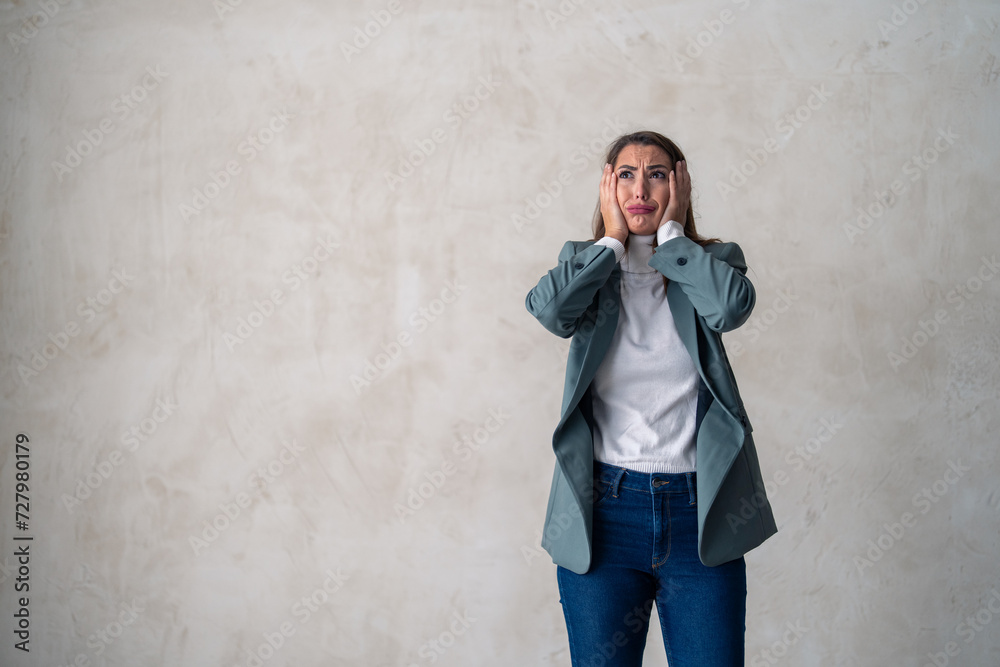 Devastated young business woman about to cry, can't handle her problems, modern life pressure, posing in a studio against a gray background with copy space. Devastated young business woman about to cry, can't handle her problems, modern life pressure, posing in a studio against a gray background with copy space.