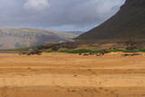View of Rauðasandur (Red Sand) beach in Westfjords, Iceland. Mountains and beautiful endless beach with sand that changes color depending on the weather and time of day