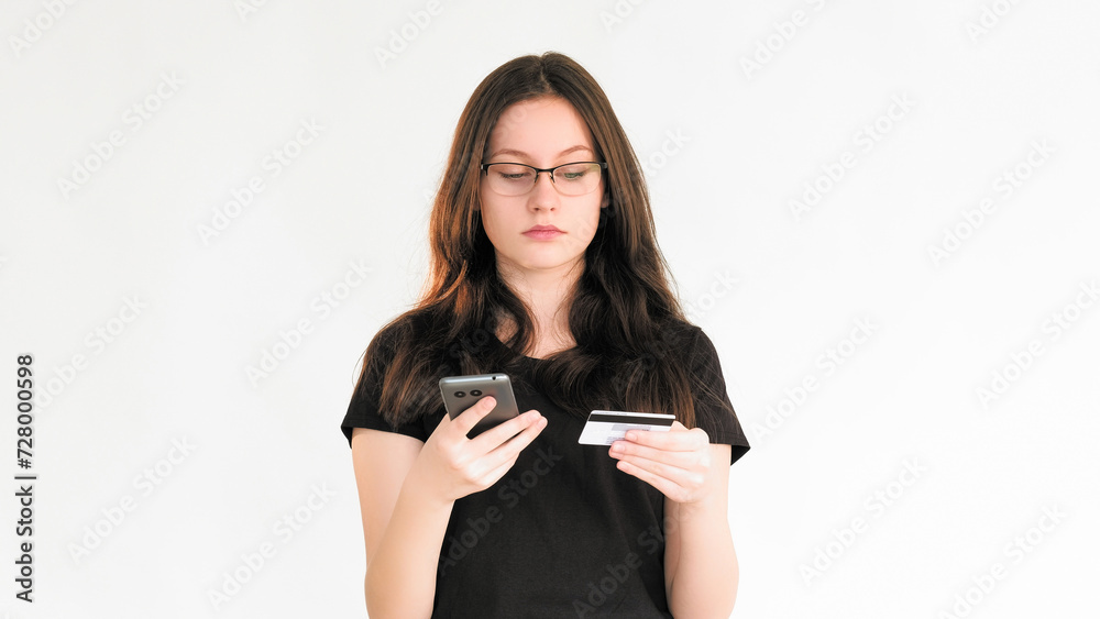 Naklejka premium Bank scam. Transaction risk. Personal data security. Confused woman using phone credit card information for Internet payment isolated on white copy space background.