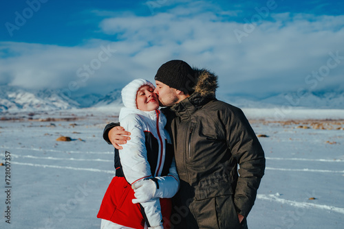 Romantic young couple kissing on mountains background in winter