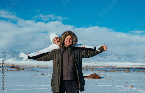 Happy young couple embracing on mountains background in winter