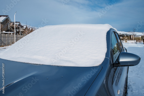 Snow covered car windshield in cold winter weather