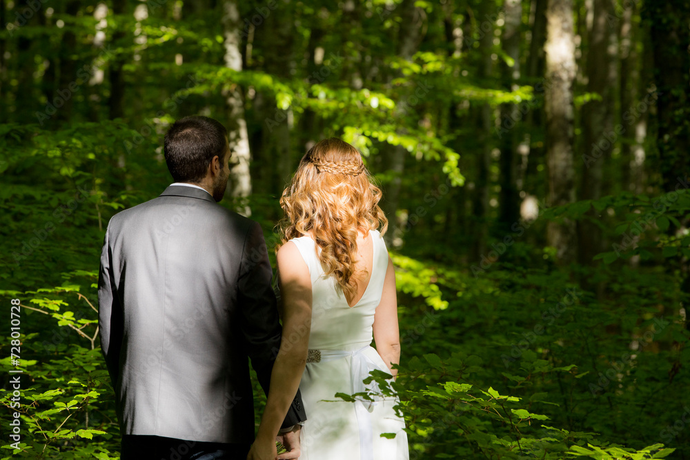 Newly married couple walking through the spring forest in La Fageda d en Jorda, La Garrotxa, Spain