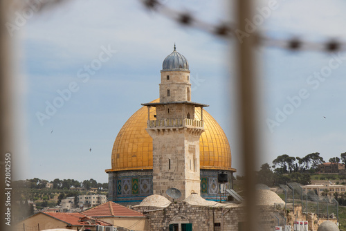 The Dome of the Rock and Bab al-Silsila Minaret, seen through barbed wire. Jewish and muslim conflict in the middle east