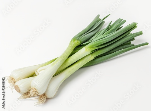 Bunch of fresh green onions with white bulbs and vibrant stems, isolated on a white background.
