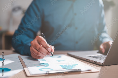 business, finance, investment, financial, document, report, budget, account, accounting, analysis. businessman one hand typing keyboard and another use pen to calculation report and confirm to invest.