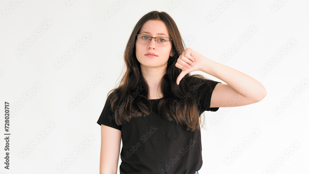 Dislike sign. Bad feedback. Reject no. Negative disapproval. Skeptic woman refusing with thumb down hand gesture isolated on white empty space background. Dislike sign. Bad feedback. Reject no. Negative disapproval. Skeptic woman refusing with thumb down hand gesture isolated on white empty space background.