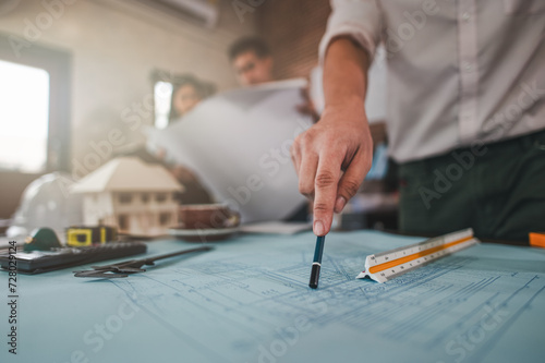 architecture, architect, construction, engineer, project, design, blueprint, house, model, plan. architects, engineer holding pen pointing equipment architects on the desk with a blueprint in office.