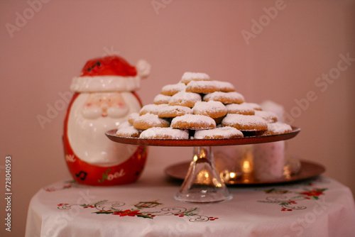 Delicious christmas cookies on a plate with powdered sugar, on a wooden table