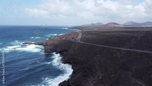 drone shooting upwards of a coastal with lava land and ocean to lanzarote in spain. 
Right road and ocean.