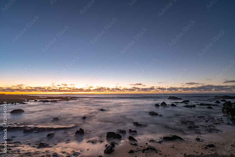 Sunrise on the Kaloko Beach in Honolulu Oahu Hawaii. wilight is light produced by sunlight scattering in the upper atmosphere, when the Sun is below the horizon, which illuminates the lower atmosphere