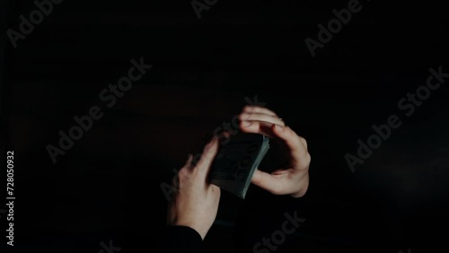 close-up of male hands counting a stack of hundred-dollar US banknotes. a businessman is counting cash. the concept of investment, money exchange. selective focus. takes money out of the wallet