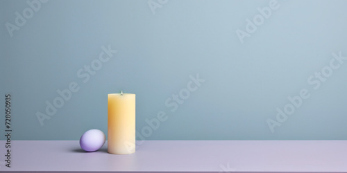 Creamy candle beside a pastel purple sphere on a clean surface  modern minimalist composition.