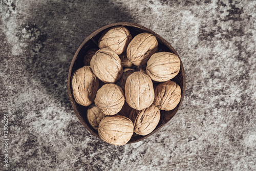 A bowl with whole walnuts in shells. Fresh organic nuts. Overhead view.