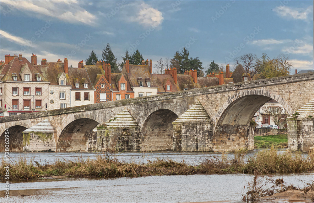 Fototapeta premium Looking across a river at a ancient bridge and town