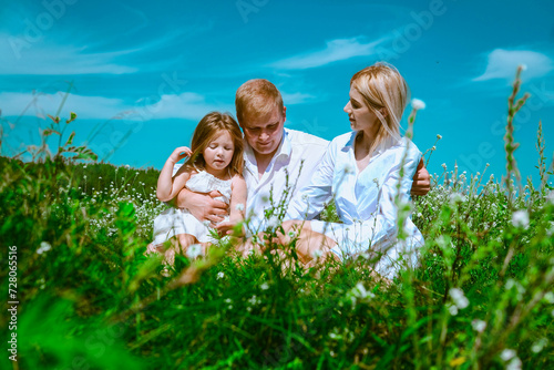 A family are walking and playing on a summer meadow. Blue sunny sky and funny emotion © Yevhen