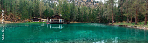 Panoramic view of turquoise water alpine lake Ghedina with restaurant in Dolomiti mountains, Cortina dAmpezzo, Italy ii springtime. Small lake in the forest in Dolomites in Italian Alps