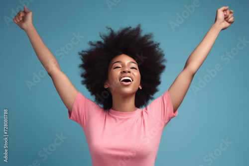 Happy young African American woman with raising her arms