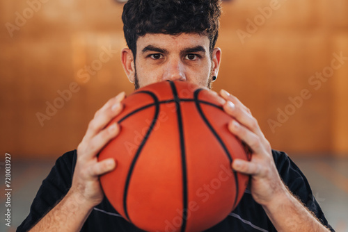 Close up of a professional basketball player holding a ball on court.