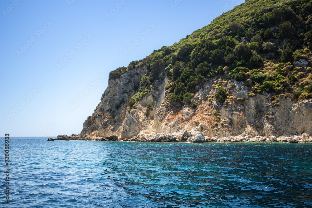 Rocky Island with Green Trees in Keri during Summer Day in Greece. Beautiful Water Color with Marathonisi in Zakynthos. Idyllic Scenery in Europe. Rocky Island with Green Trees in Keri during Summer Day in Greece. Beautiful Water Color with Marathonisi in Zakynthos. Idyllic Scenery in Europe.