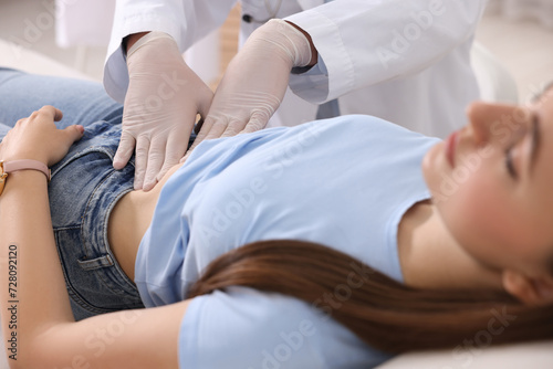 Gastroenterologist examining patient with stomach pain in clinic, closeup