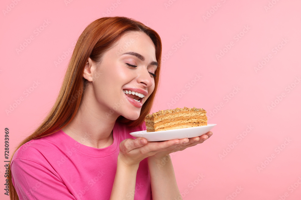 Young woman with piece of tasty cake on pink background, space for text