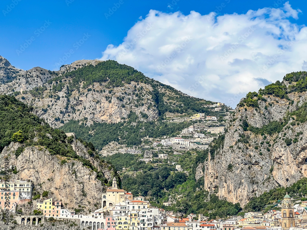 View from the sea of beautifully situated buildings on the slopes of the mountains in Amalfi, Campania, Italy